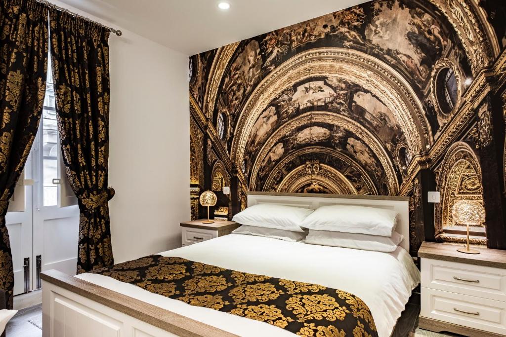 瓦莱塔Jean de Valette Boutique Living的一间卧室配有一张带壁画的大床