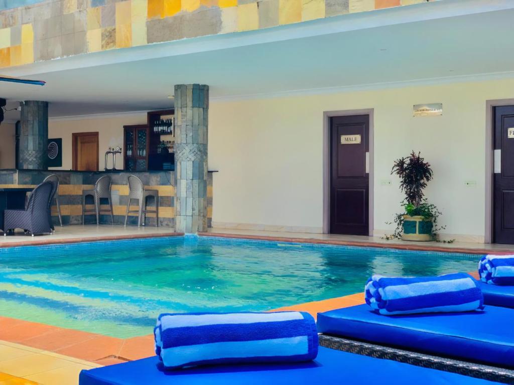 达累斯萨拉姆CBD Hotel的一座建筑中带蓝色垫子的大型游泳池