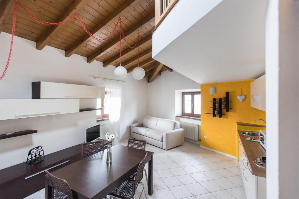 阿科Casa Lidia, la mansarda sul fiume的厨房以及带桌椅的起居室。