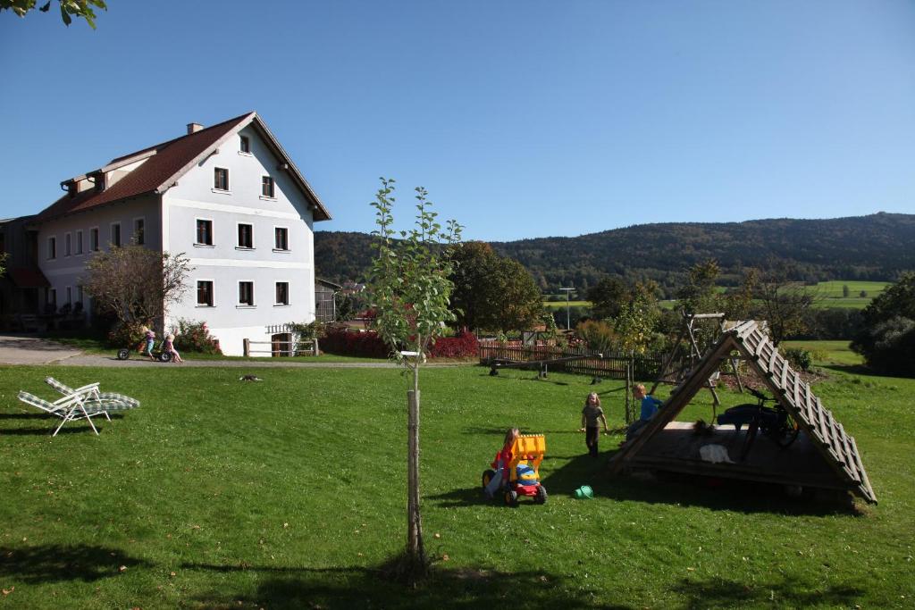 SchönseeHanauerhof的一群人在田野里和房子玩耍