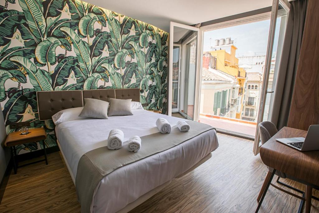 马拉加Málaga Premium Hotel的一间卧室配有带毛巾的床