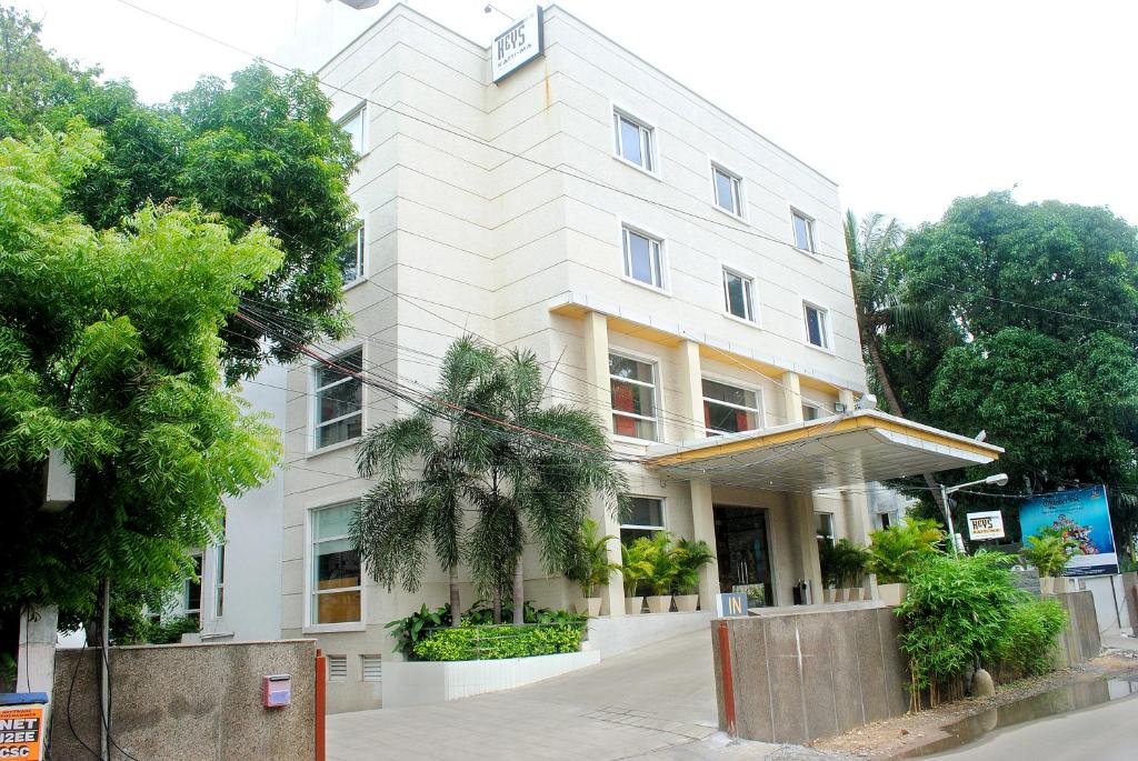 钦奈Keys Select by Lemon Tree Hotels, Katti-Ma, Chennai的前面有树木的白色大建筑