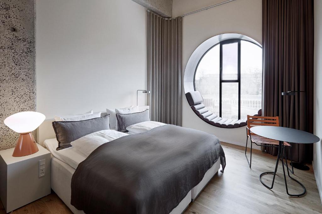 哥本哈根Hotel Ottilia by Brøchner Hotels的一间卧室设有一张大床和一个圆形窗户。