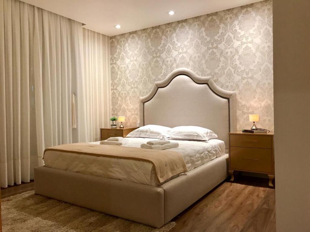 特雷齐蒂利亚斯Alpen Hospedagem的一间卧室配有一张大床和大床头板