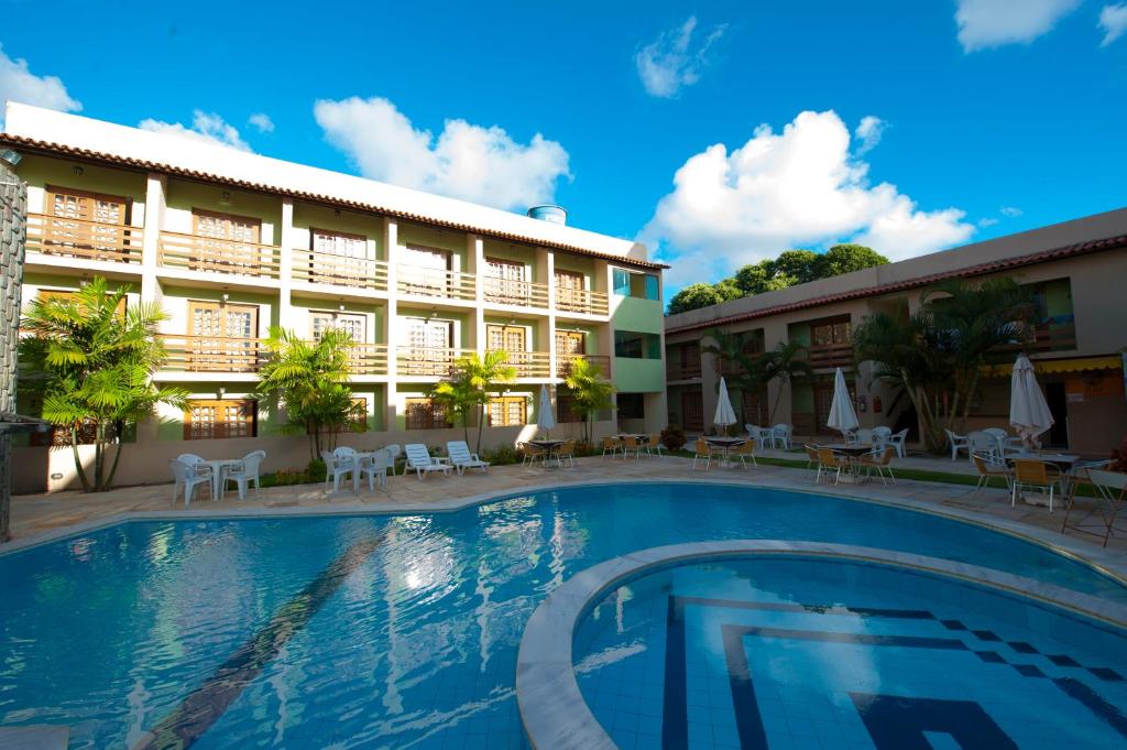 嘎林海斯港Estação do Sol Praia Hotel的大楼前设有游泳池的酒店