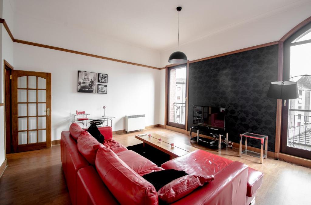 阿伯丁City Centre Orange Apartments Bastille的客厅配有红色沙发和电视