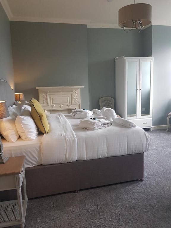 伍德福德The Royal Oak的卧室配有一张带白色床单和枕头的大床。