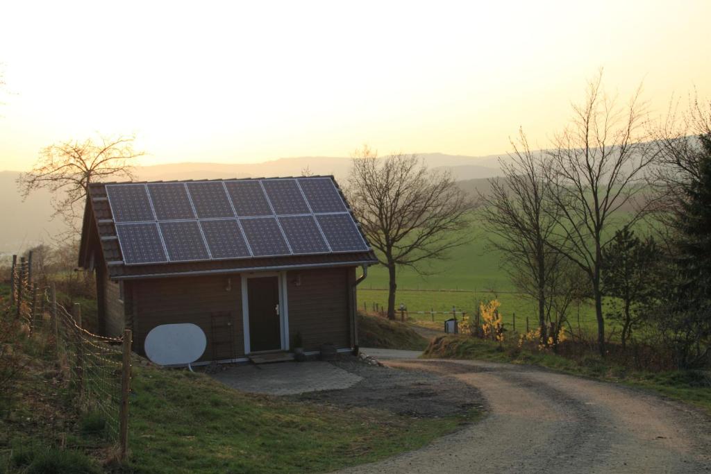 OsterspaiHof Marienberg, 56340 Osterspai, Deutschland Wanderhütte的路边设有太阳能电池板的房子