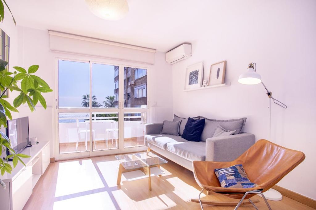 马拉加Malagueta Blue的带沙发和大窗户的客厅