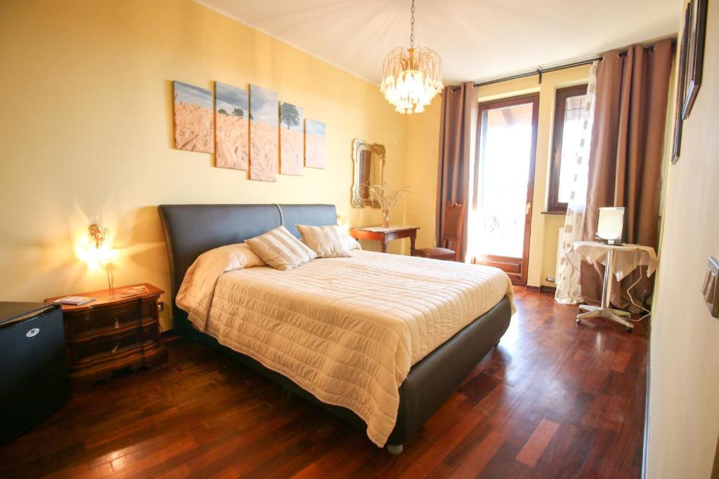 Candia CanaveseSpighe Paglia e Girasole的一间卧室配有一张床和一个吊灯