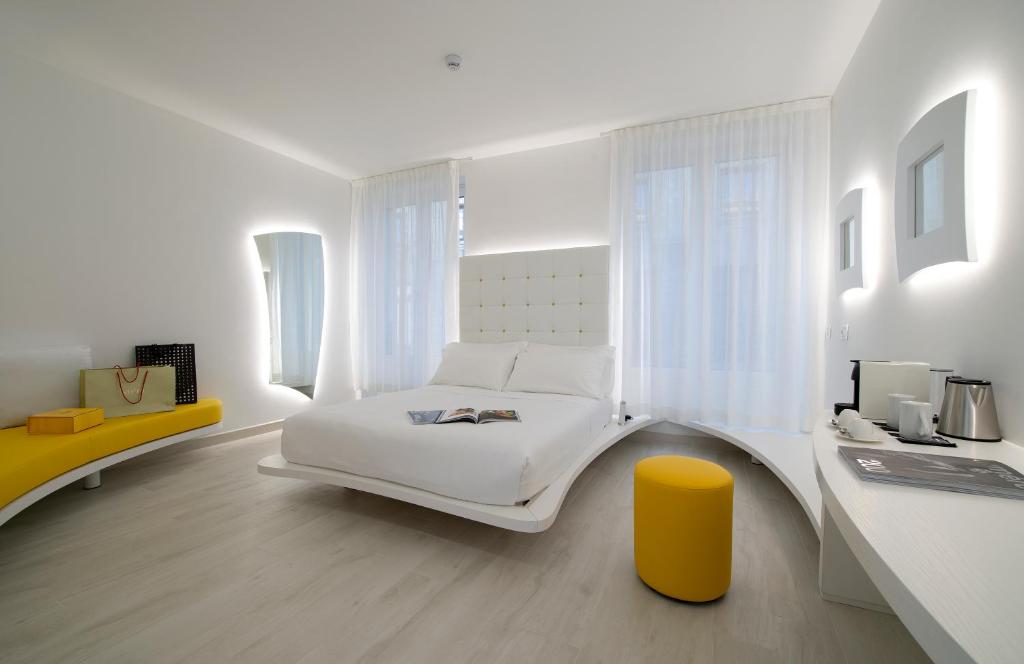 米兰AHD Rooms的白色卧室配有白色的床和黄色凳子