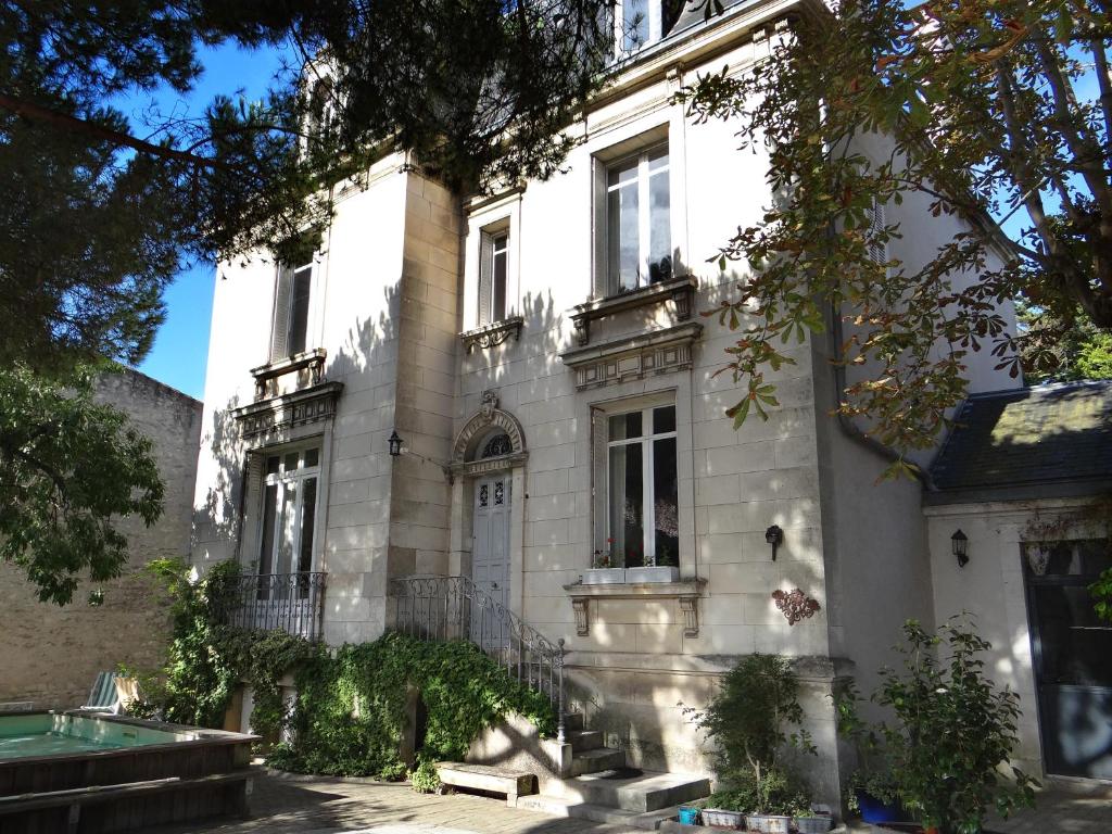 拉罗谢尔Chambres d'hôtes Le Clos Bleu的一座大型白色房子,前面设有一个游泳池