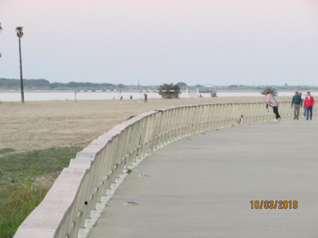 桑卢卡尔-德巴拉梅达CALLE YERBABUENA 5的一座海滩上的桥梁,人们在上面行走