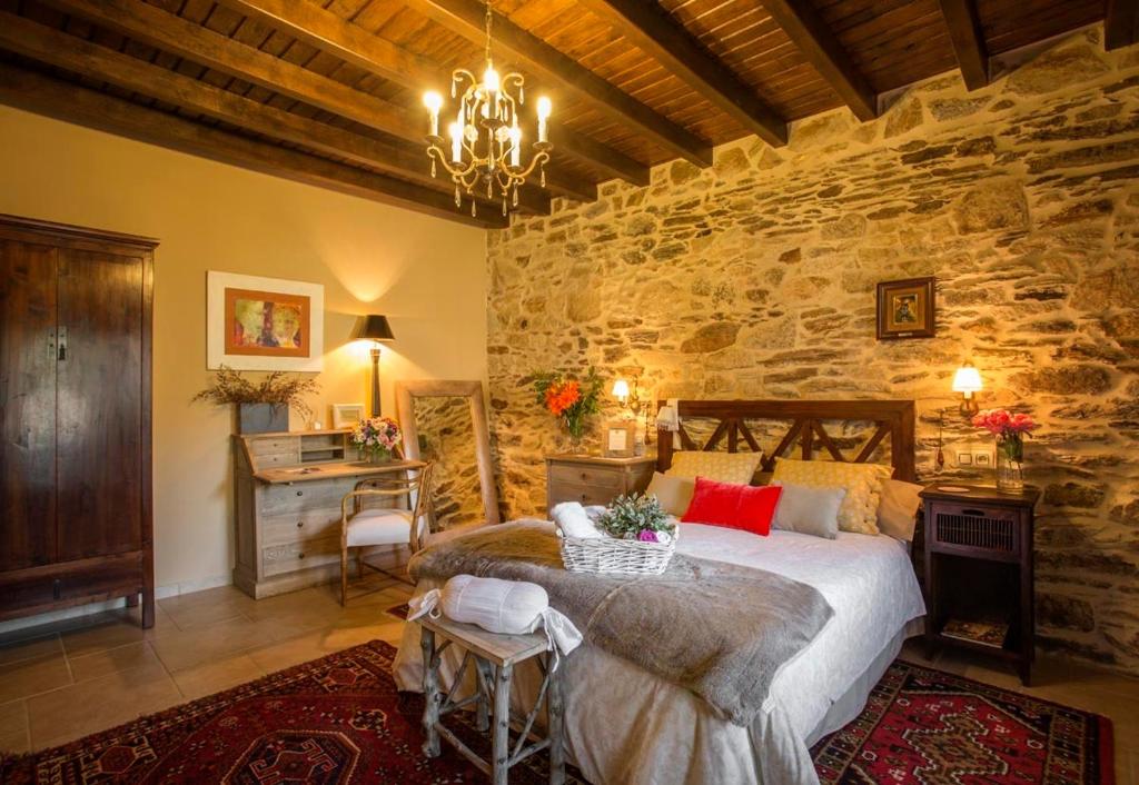 O Viso卡萨莱米拉酒店的卧室配有一张石墙内的大床