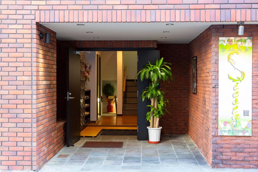 东京Guest House Siesta的砖砌的建筑,有门,有植物