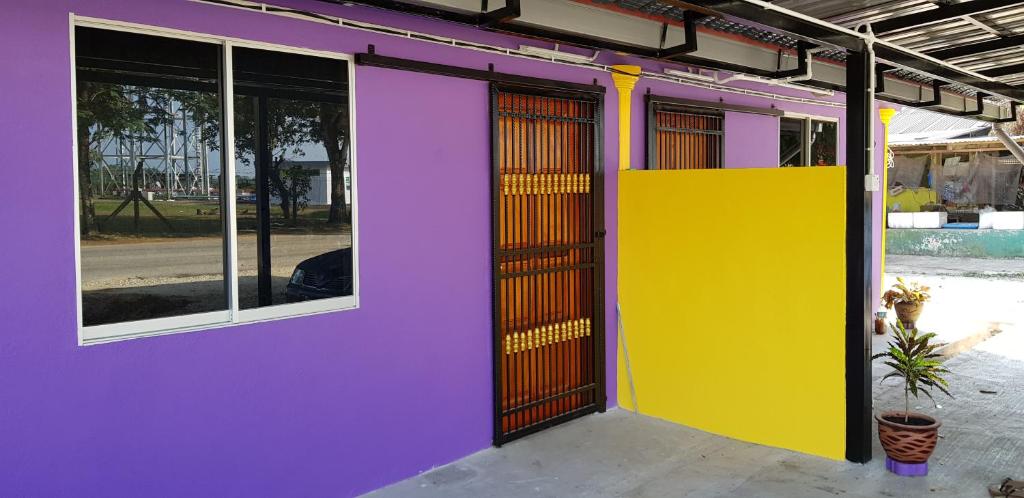关丹Homestay Che Kiah的紫色和黄色的外墙,带有窗户