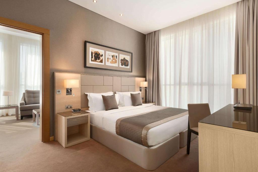 阿布扎比阿布扎比市中心爵怡温德姆酒店的配有一张床和一张书桌的酒店客房