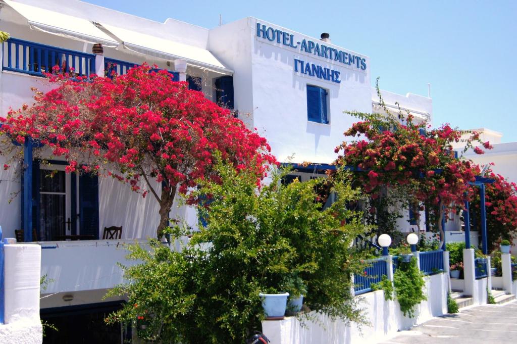 阿达玛斯Hotel Apartments Giannis的一排白色的建筑,上面有红色的花朵