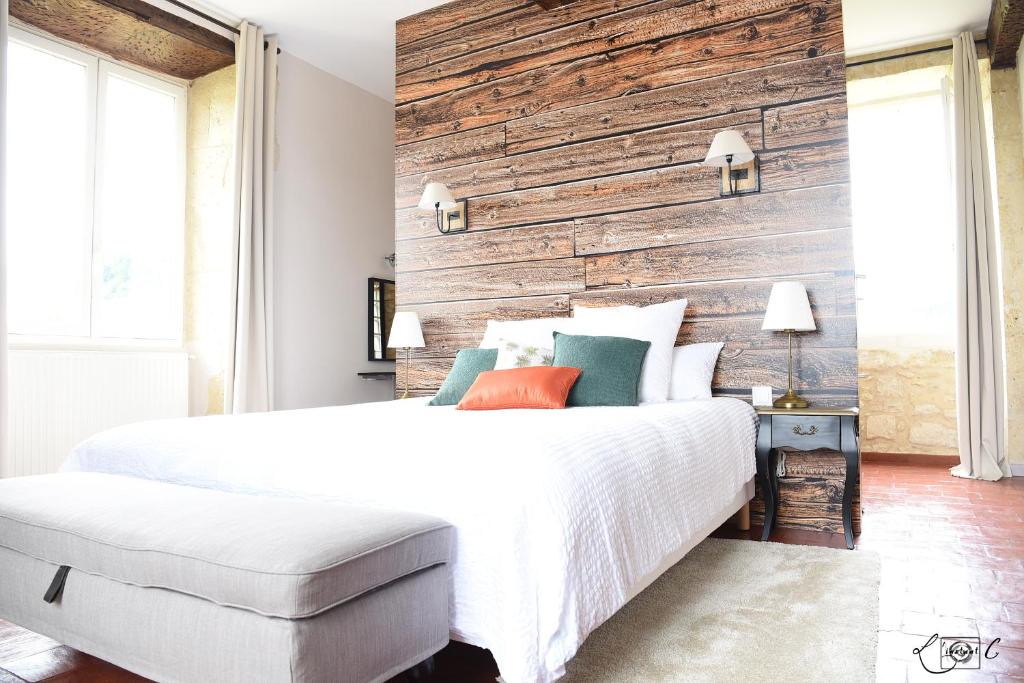 欧什A CLAIREFONTAINE的卧室配有白色的床和木墙