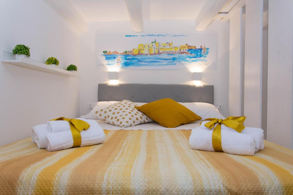 锡拉库扎Little House的一间卧室配有黄色和白色枕头的床