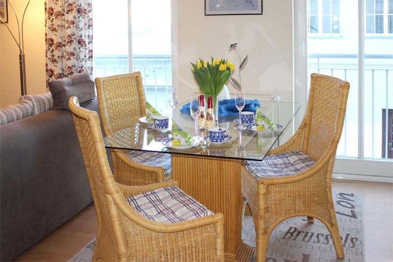 奥斯赛拜-屈隆斯博恩Appartementhaus Olymp的餐桌、椅子和花卉玻璃桌