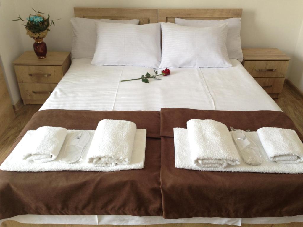 哥里Hotel Continental的一张带白色毛巾和红色花的床铺