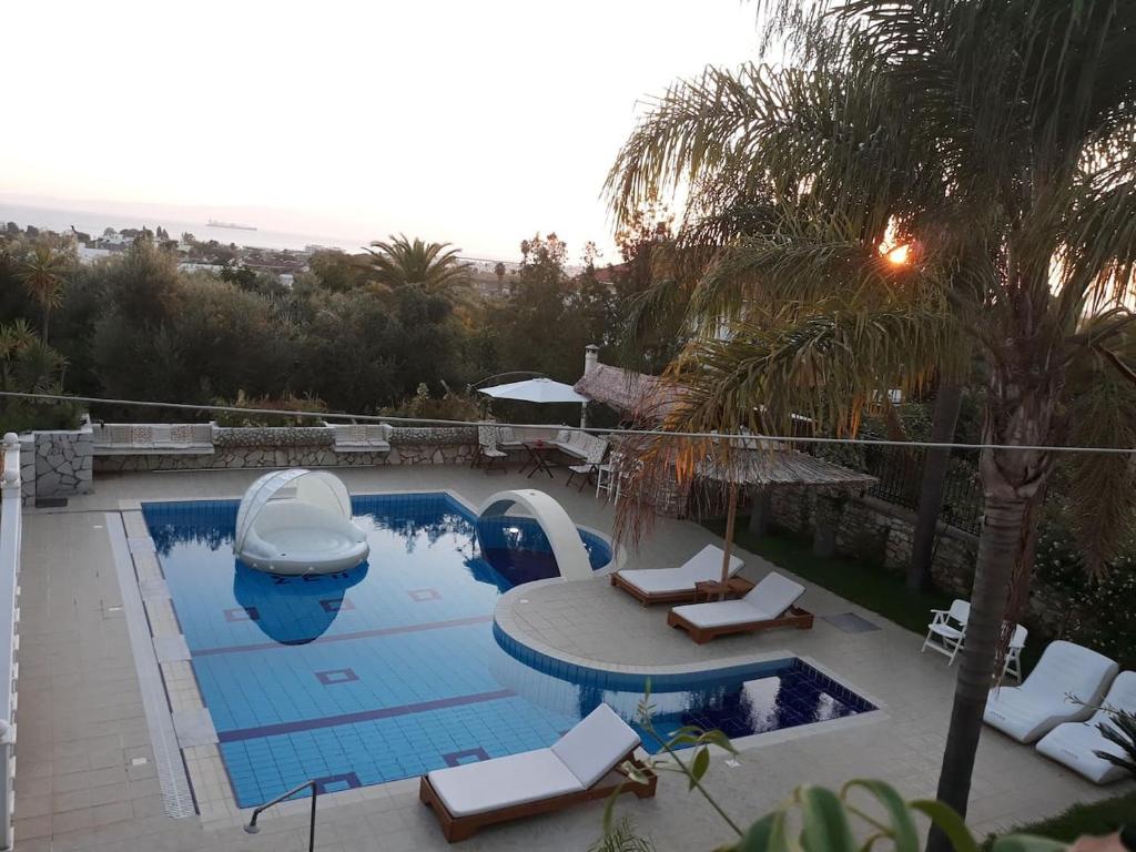 卡拉马塔Luxury Country House in Kalamata / SP的游泳池设有两把躺椅和一条小船
