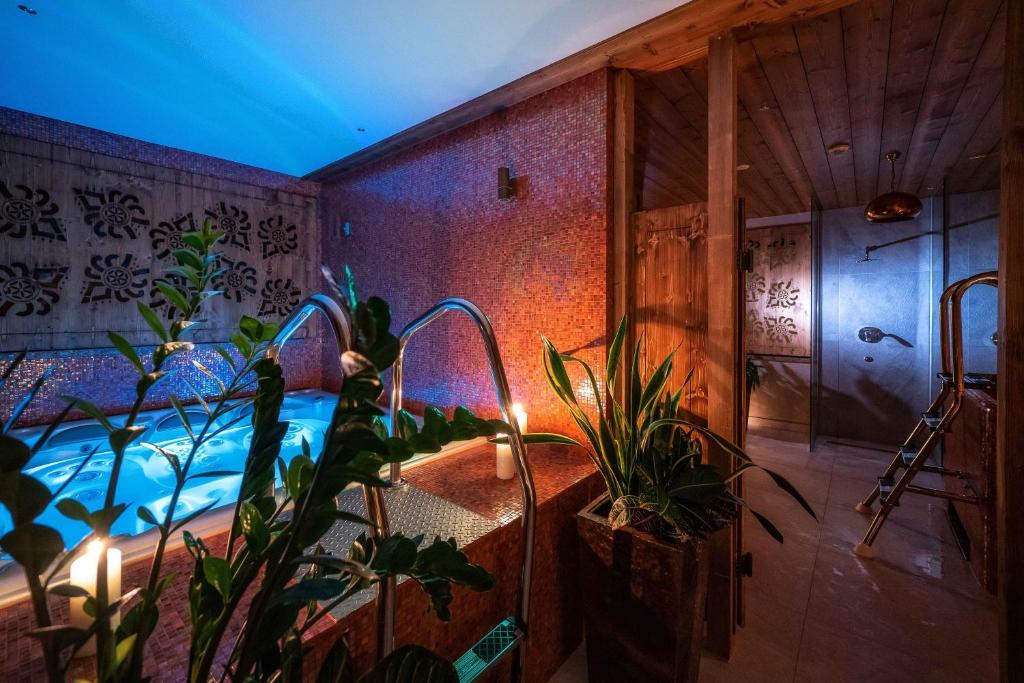 扎科帕内Gold Hotel的一间设有植物热水浴缸的客房