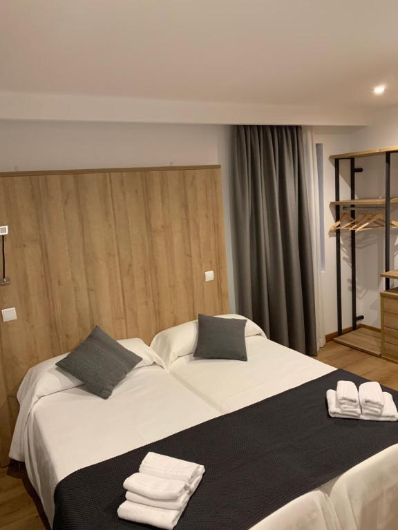 佩德勒纳hotel la trainera的卧室配有带毛巾的大型白色床