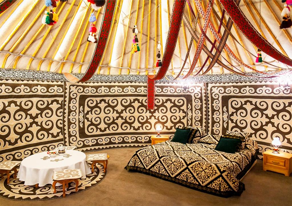 BesqaynarOi-Qaragai Mountain Resort的一间设有床铺和桌子的房间