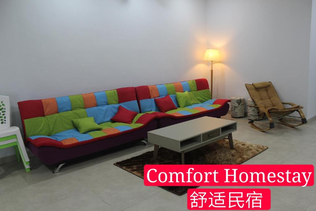 麻坡Muar Homestay (Comfort Homestay)的客厅配有色彩缤纷的沙发和桌子