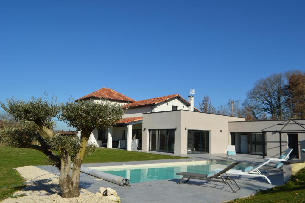 CaumontVilla au coeur du Gers avec vue sur les Pyrénées的一座带游泳池和房子的别墅