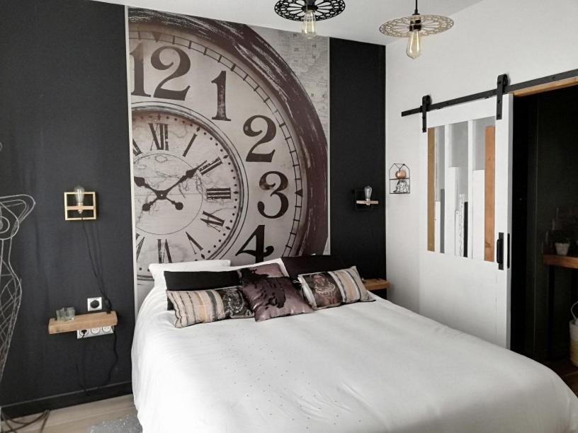 Octeville-sur-MerEntre Honfleur et Etretat的卧室配有墙上的大时钟