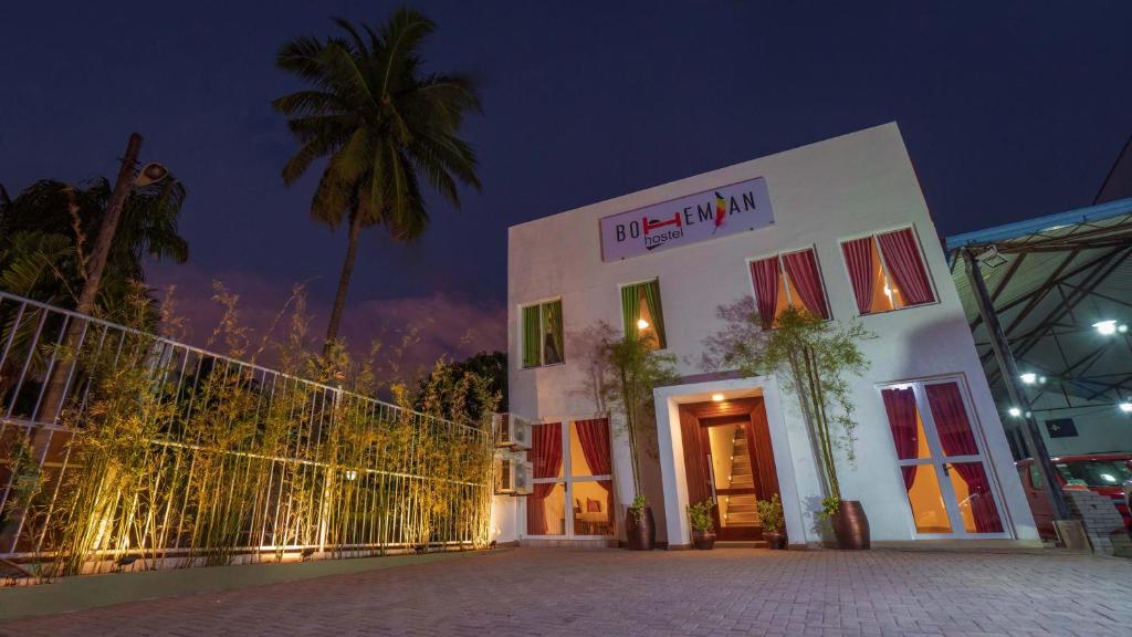 尼甘布Bohemian Hotel - Negombo的白色的建筑,晚上有棕榈树