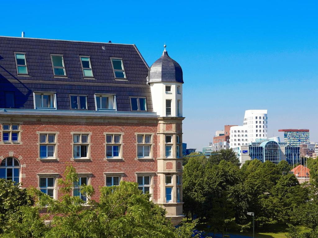 杜塞尔多夫红色公寓酒店的砖砌的建筑,上面有钟楼