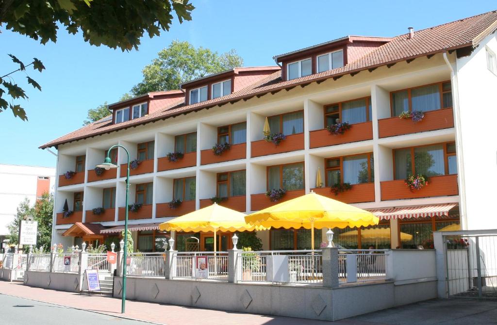巴特塔茨曼斯多夫Hotel zum Kastell的前面有黄色雨伞的酒店