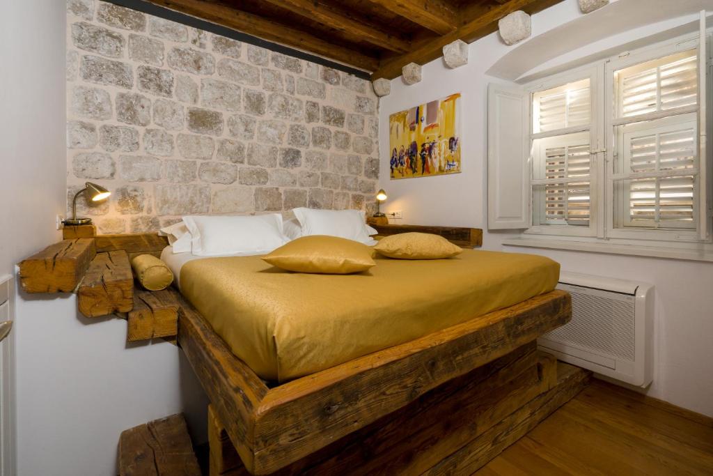 杜布罗夫尼克尼耶普雷萨公寓酒店的一间卧室设有一张床和石墙