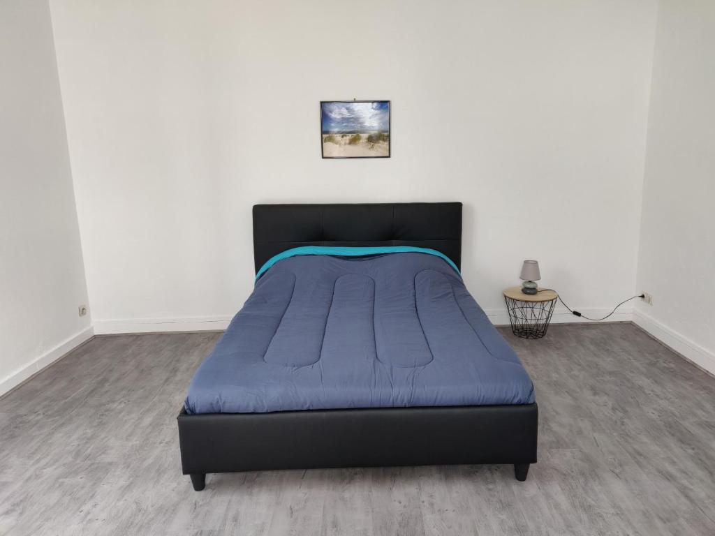 圣纳泽尔Hébergement Paquebot de Rêve的一间卧室配有一张带蓝色毯子的床