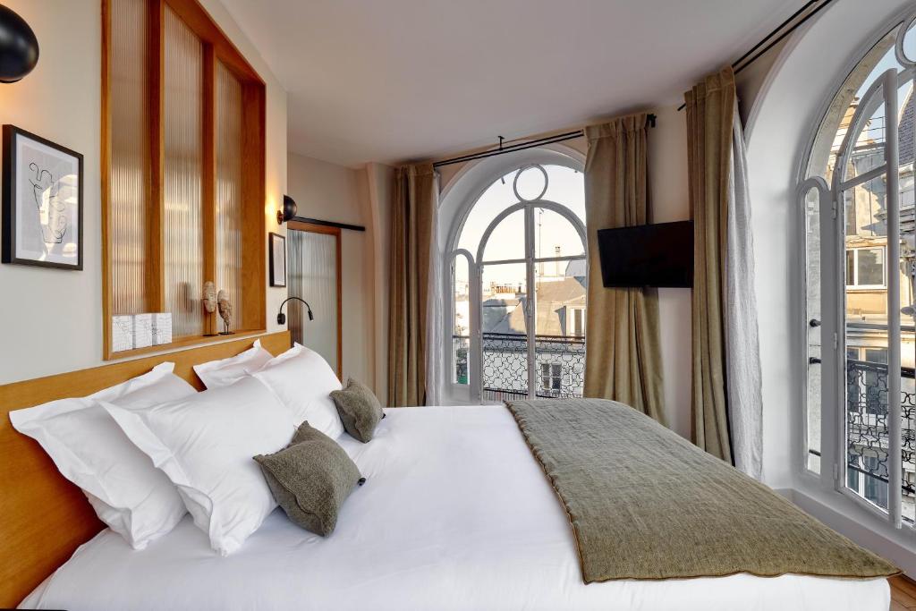 巴黎Tinah Paris, Réaumur - Montorgeuil的卧室设有白色的床和大窗户