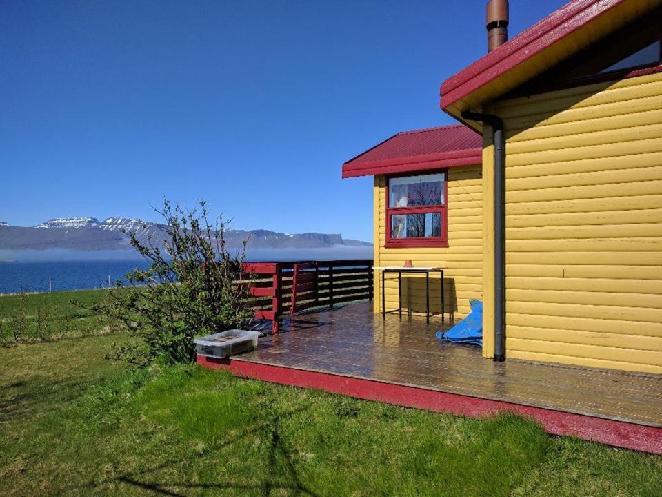 ÞingeyriGemlufall guesthouse的水边的黄色房子