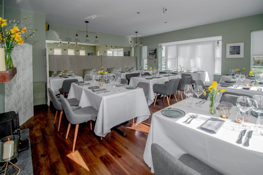 杜林Oar restaurant and Rooms的一间设有白色桌椅的用餐室
