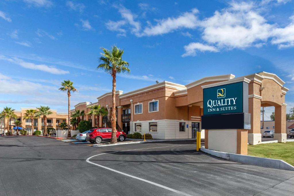 梅萨Quality Inn & Suites near Downtown Mesa的棕榈树建筑前的标志