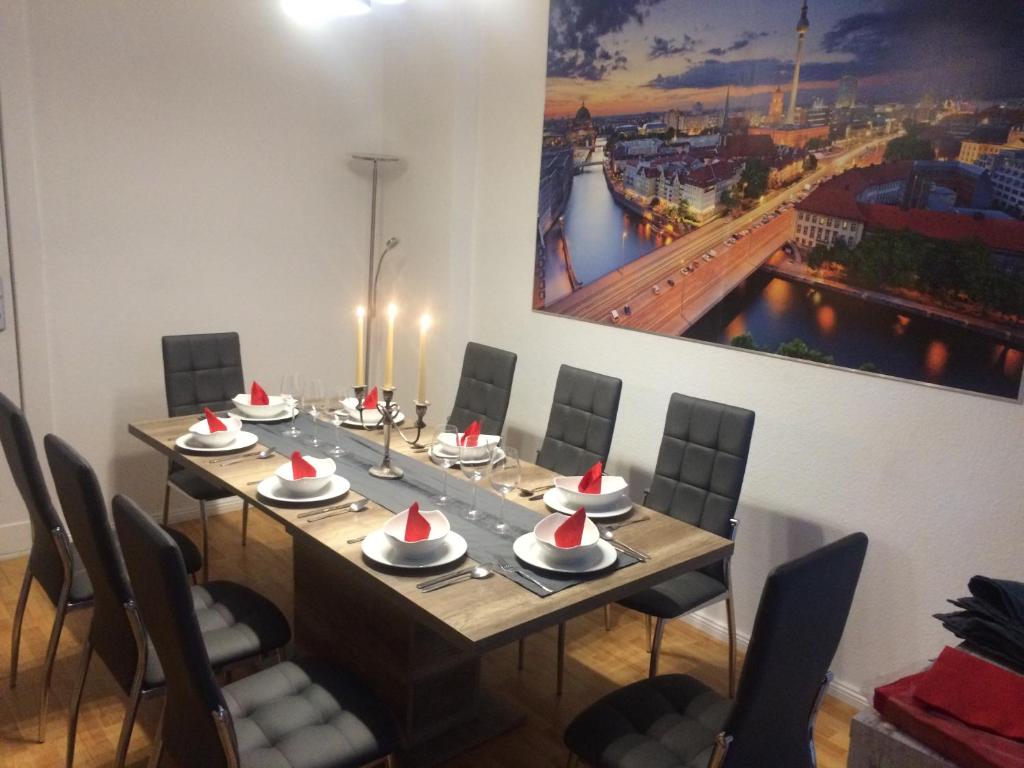 柏林City-Apartment Zille的用餐室配有长桌子、椅子和绘画作品