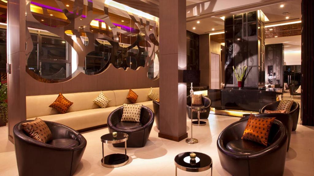 曼谷曼谷M2酒店的大楼内一个带沙发和椅子的大堂