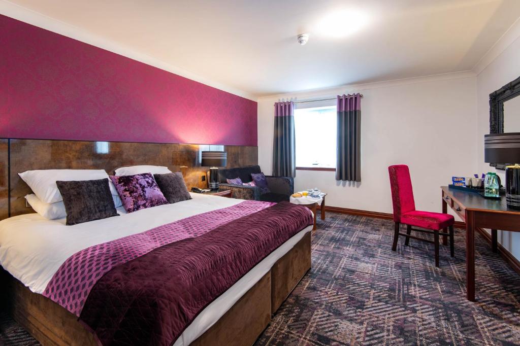 奥尔德姆曼彻斯特罗盘酒店集团维多利亚酒店的酒店客房设有一张大床和一张书桌。