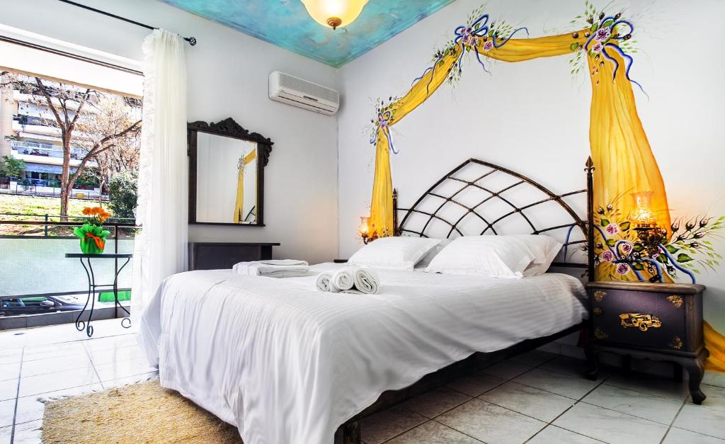 雅典Stylish apartment next to Thiseio and Keramikos的卧室配有一张带白色床单和黄色窗帘的床。