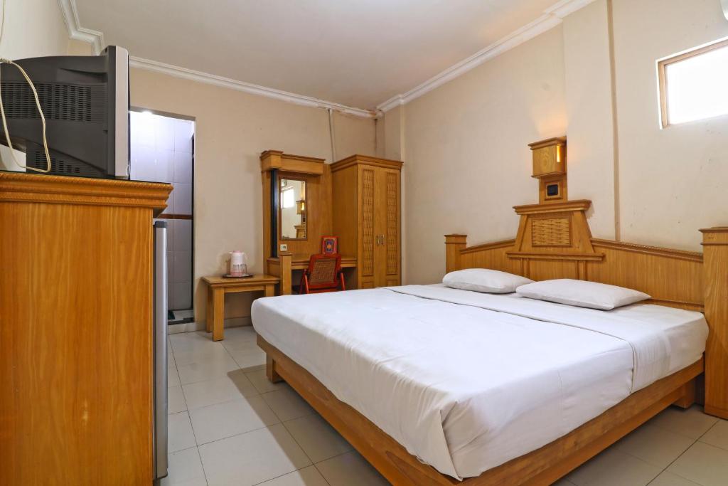 班贾尔马辛Hotel SAS Syariah的一间卧室配有一张床和一台电视