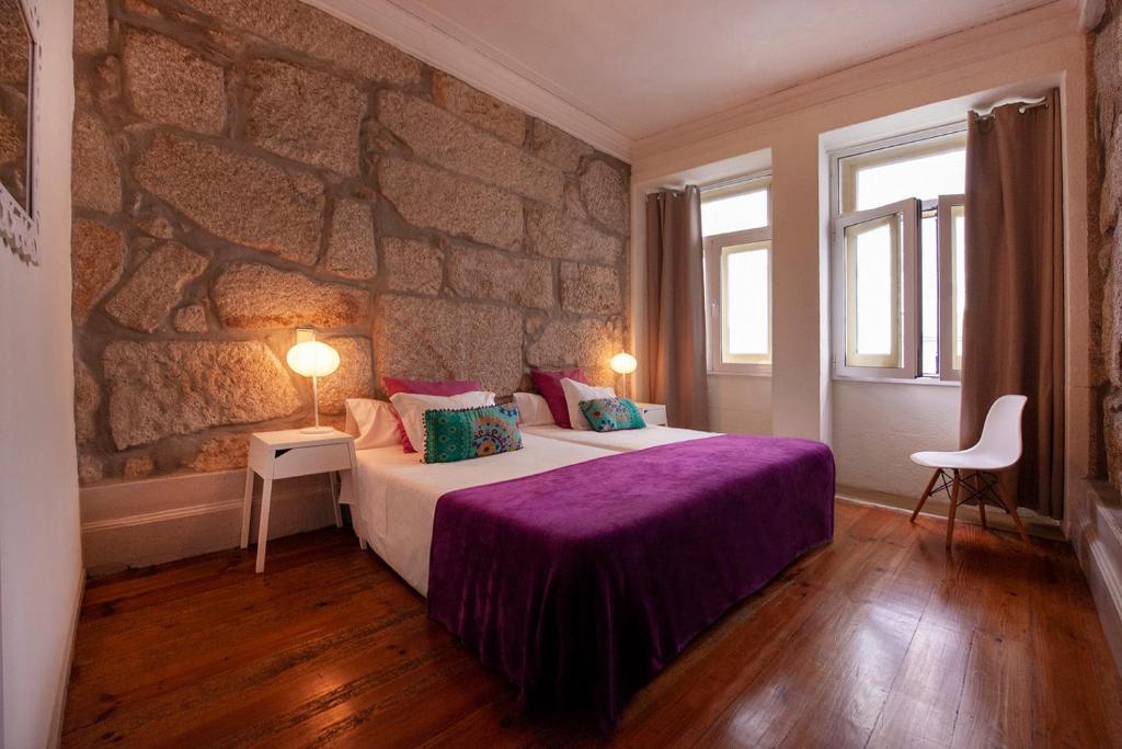 波尔图欧博托别墅的一间卧室设有一张带石墙的大床