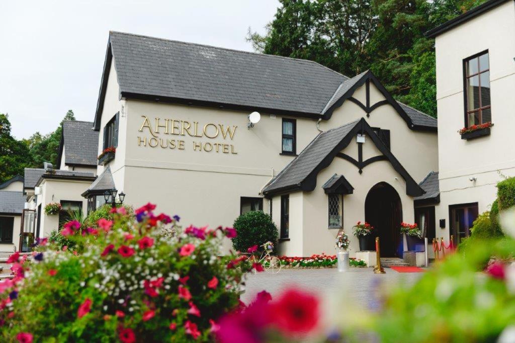 Aherlow阿尔罗小屋酒店的白色的房子,上面有读着祭坛的标志