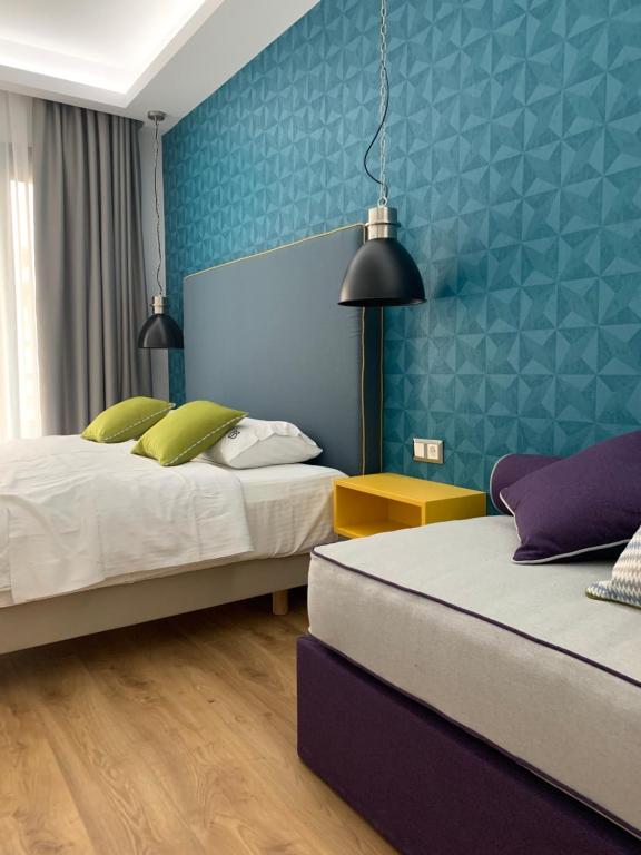 塞萨洛尼基White Bottle Superior Apartments的一间卧室设有两张床和蓝色的墙壁